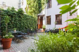 patio ze stołami, krzesłami i roślinami w obiekcie Hotel Czarna Róża w Toruniu