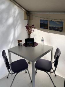 a table with two chairs and a laptop on it at Vines and Puppies Glamping Hideaway in Jade City