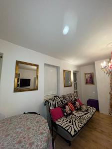 - un canapé à motifs zébrés dans une chambre avec un lit dans l'établissement Apartament nad Balatonem, à Varsovie