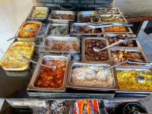 a buffet filled with many trays of food at Tijota Hotel Fazenda in Ipatinga