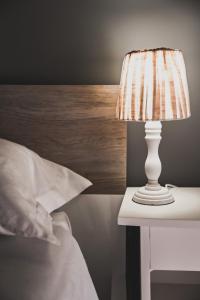 eine weiße Lampe auf einem Tisch neben einem Bett in der Unterkunft La Casina B&B in Marina di Schiavonea