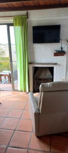 a living room with a couch and a flat screen tv at Ancora in Punta Del Diablo