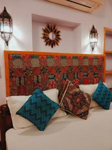 a bedroom with a bed with pillows and a headboard at Shanti Home in Jaisalmer