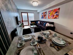 - un salon avec une table à manger et des assiettes dans l'établissement Apartament Jelonek w Karkonoszach, à Jelenia Góra