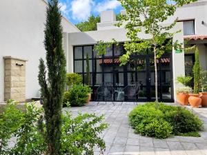 un patio con sillas y plantas frente a un edificio en Huli B&B en Mendoza