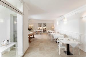 a dining room with white tables and white chairs at Masseria Mongiò dell'Elefante in Otranto