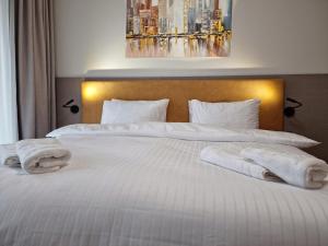 a bedroom with two white towels on a bed at JBX Resort Avenue Lipno in Lipno nad Vltavou