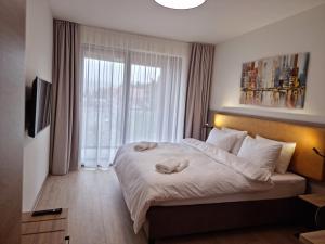 Un dormitorio con una cama grande y una ventana en JBX Resort Avenue Lipno en Lipno nad Vltavou