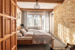 sypialnia z łóżkiem i ścianą z cegły w obiekcie Górski klimat Apartament w Zakopanem +13 zdjęć