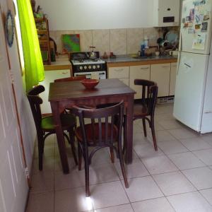 cocina con mesa, sillas y nevera en casa de ensueño en La Falda