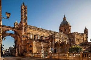 duży kamienny budynek z wieżą zegarową i katedrą w obiekcie CASA DEI SOGNI w mieście Palermo