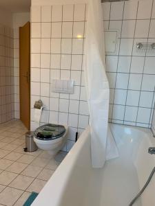 La salle de bains est pourvue de toilettes et d'une baignoire. dans l'établissement Blue Chili 21 - Großzügige Altbauwohnung bis 7 Personen WLAN Balkon, à Magdebourg