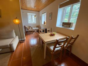 uma sala de estar com uma mesa e um sofá em Ribeira dos Caldeirões em Achada