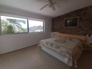 a bedroom with a bed and a large window at CASA DE DESCANSO VILLA DIAMANTE in Acapulco