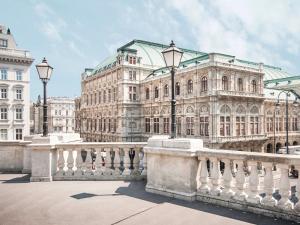 a large building with a fence in front of it at 1st City Apartments in Vienna