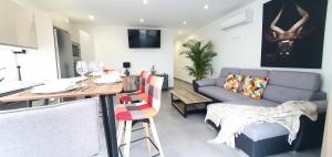 a living room with a table and a couch at HD Mogán Canal Apartments in Puerto de Mogán