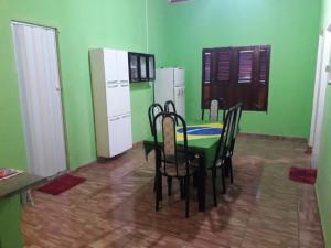 a green kitchen with a table and chairs and a refrigerator at Casa Gael (Gisele & Lucimar) in Atins