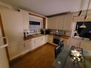 a small kitchen with white cabinets and a table at Ferienwohnung mit Terrasse für bis zu 4 Personen in Balve
