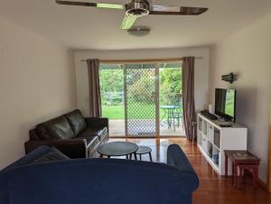sala de estar con sofá azul y TV en 8 Sailor's Retreat en Marlo