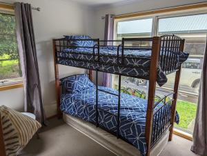 2 łóżka piętrowe w pokoju z oknem w obiekcie 8 Sailor's Retreat w mieście Marlo