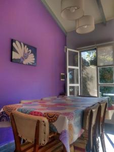 a dining room with a table and purple walls at La Casa de Liber in Tandil
