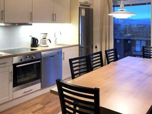 a kitchen with a table and chairs and a kitchen with a view at 8 person holiday home in S LEN in Stöten