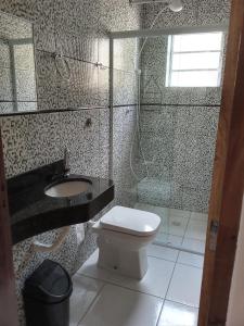 a bathroom with a toilet and a sink and a shower at Casa de Praia da Ju - Caraguatatuba in Caraguatatuba