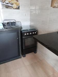 a kitchen with a black stove and a counter at Casa de Praia da Ju - Caraguatatuba in Caraguatatuba