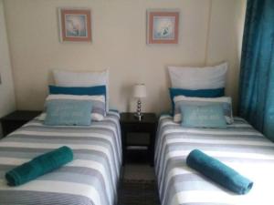 2 camas individuales en una habitación con cortinas azules en Cerf@BeachFront, en Margate 6 fotos más