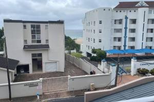 Una vista de un edificio y el océano desde un balcón. en Cerf@BeachFront, en Margate