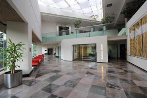 een lege lobby met een bank en een trap bij Radisson Paraiso Hotel Mexico City in Mexico-Stad