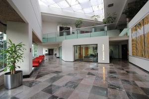 an empty lobby with a couch and a staircase at Radisson Paraiso Hotel Mexico City in Mexico City