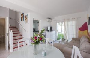 uma sala de estar com um vaso de flores sobre uma mesa em Galera Beach Boutique Art Villas with Private Pools, Free Wifi & BBQ, Corralejo by Amazzzing Travel em Corralejo