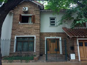 a brick house with a window and a door at Hostel Casteleyhost in Mendoza