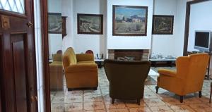 a living room with several chairs and a television at Hostel Casteleyhost in Mendoza