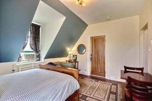 une chambre avec un lit, un bureau et une fenêtre dans l'établissement 1888 Victorian House Old Quebec City, à Québec