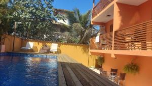 ein Hotel mit einem Swimmingpool vor einem Gebäude in der Unterkunft Cotia - Novo Flat com Piscina, 50mts da praia, churrasqueira privativa, ar con, wi-fi, netflix, garagem in Paraty