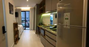 een keuken met een roestvrijstalen koelkast in een kamer bij Brooklin Studios I Em frente ao metrô Brooklin in Sao Paulo