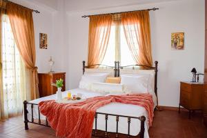 a bedroom with a bed with an orange blanket on it at Rahati Holiday Villa Maisonette by Estia in Kerásia