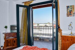 een slaapkamer met een deur naar een balkon bij Rahati Holiday Villa Maisonette by Estia in Kerásia