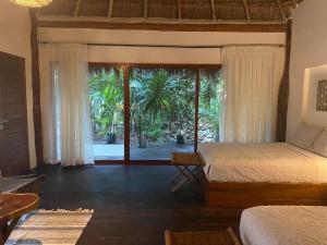 a bedroom with a bed and a large window at Xoot Ka’Ana villa fantasía in Bacalar