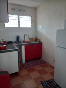 a kitchen with a red cabinet and a refrigerator at Magnifique T2 meublé avec piscine in Cayenne
