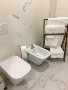 a white bathroom with a toilet and a sink at Marquês d'Aveiro Suite in Aveiro