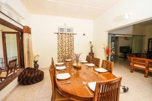 una sala da pranzo con tavolo e sedie in legno di Camellia Dwelling a Hikkaduwa