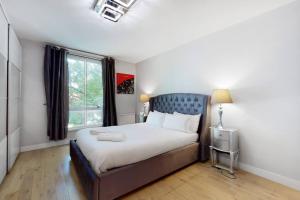 Un dormitorio con una cama grande y una ventana en Superb 3 bed flat with balcony in St John's Wood en Londres