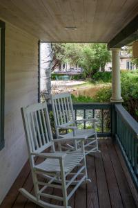 dwa białe bujane krzesła siedzące na ganku w obiekcie Apple Orchard Inn w mieście Durango