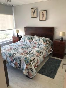 - une chambre avec un lit et une couette à fleurs dans l'établissement Departamento 3 poniente Viña del Mar, à Viña del Mar