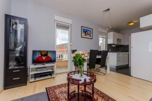 una sala de estar con un jarrón de flores sobre una mesa en Apartment Rocky, en Trogir