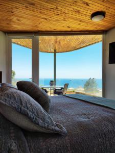 a bedroom with a bed with a view of the ocean at Hostal lala porteña vista al mar, baño privado y desayuno in Valparaíso