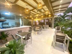 ein Restaurant mit Tischen und Stühlen und eine Bar in der Unterkunft Hotel Naoz in Manuel Antonio